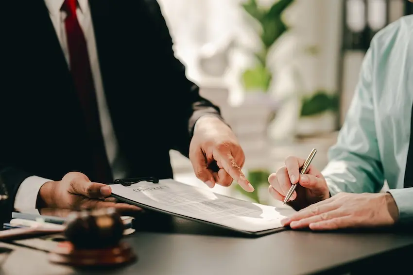 Car accident attorney reviewing legal documents and claim details with injured client in law office