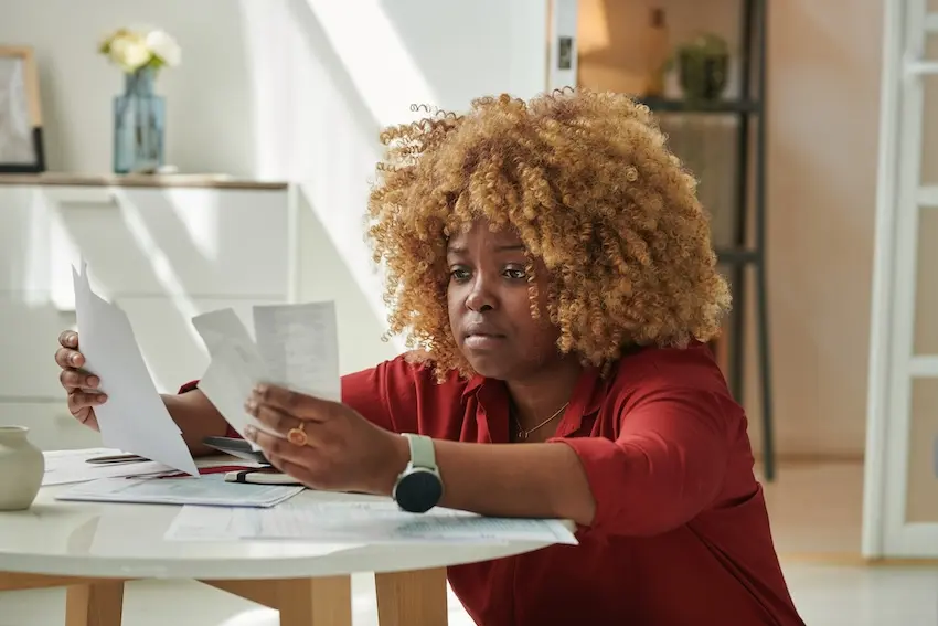 Frustrated person overwhelmed by insurance claim paperwork and documentation for car accident