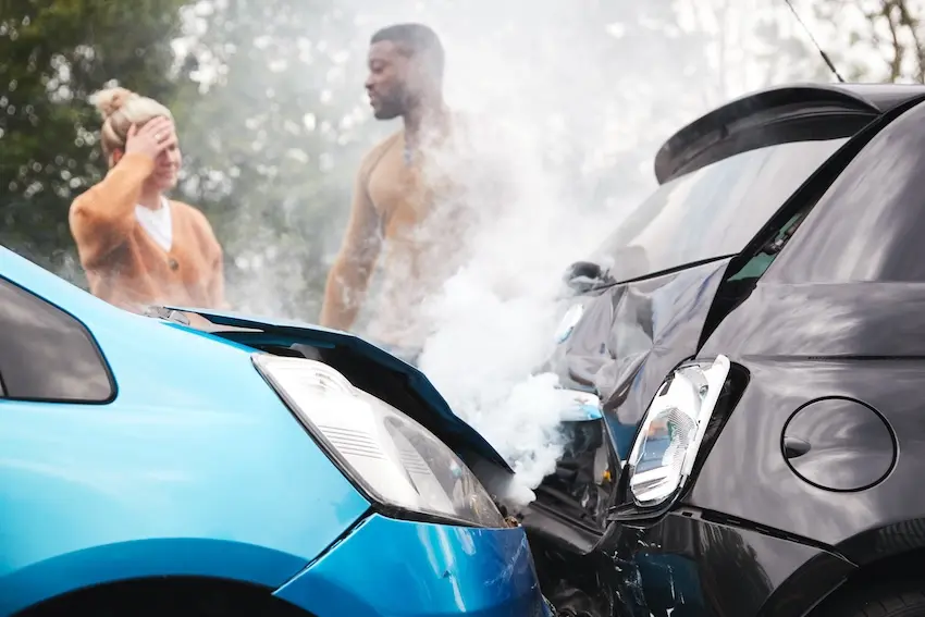 Person documenting car damage at accident scene by taking photographs with smartphone for insurance claim