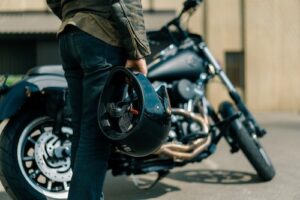 Biker Holding Motorcycle Helmet - Motorcycle Helmet Use