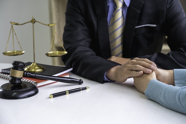 Personal injury attorney consulting with accident victim client during legal case evaluation meeting in law office