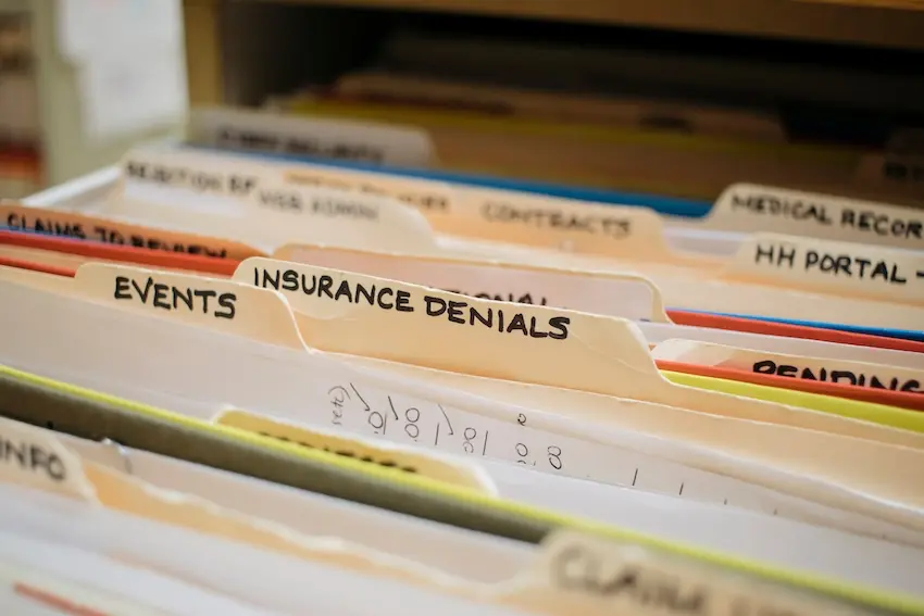 Person reviewing insurance settlement offer documents and claim paperwork on desk for personal injury case