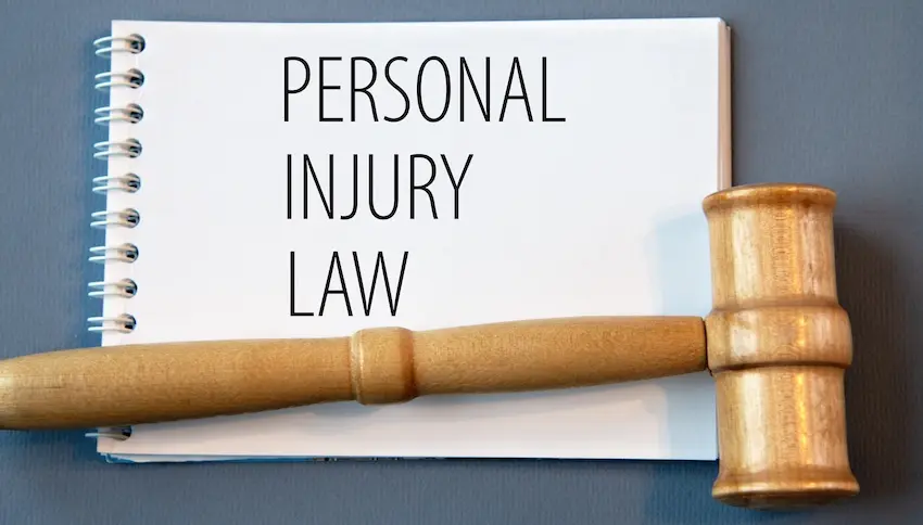 A notebook is displaying Personal Injury Law text with a wooden gavel representing legal claims and compensation cases at Ross Moore Law in Tennessee.