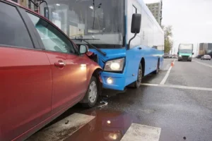 Union City car accident lawyer case showing a red sedan collided with a blue city bus on an urban street after the collision.
