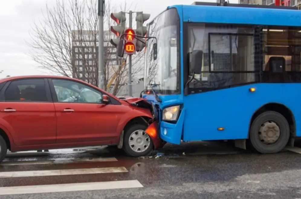 Marietta bus accident lawyer case showing a collision between a red car and a blue city bus at the intersection.